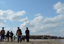 foto de la playa de Chapadmalal con niños caminado en ella. En el borde superior derecho el logo del CONICET Mar del Plata
