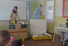 Imagen del investigador dando una clase a niños y niñas de primaria